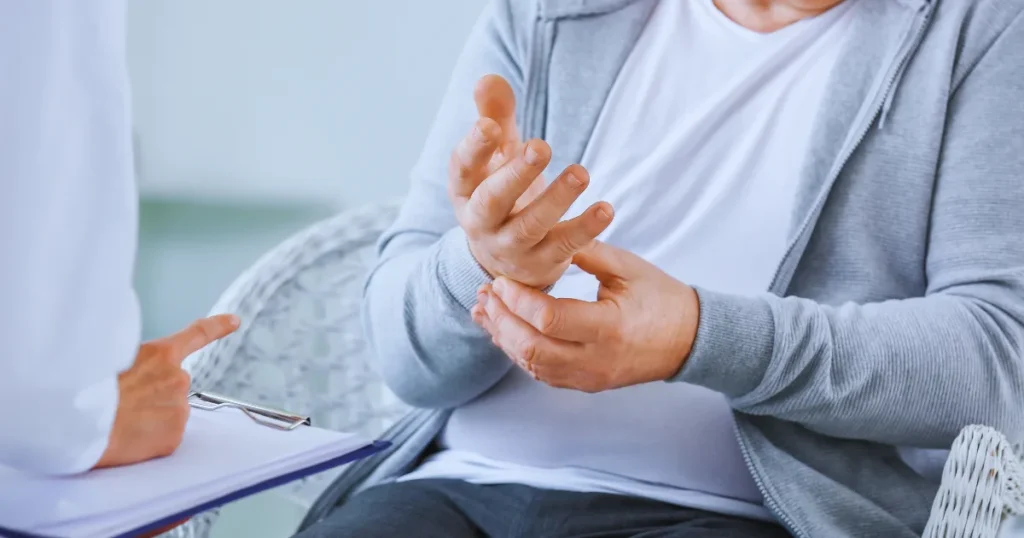 Patient showing hand tremor during consultation with doctor