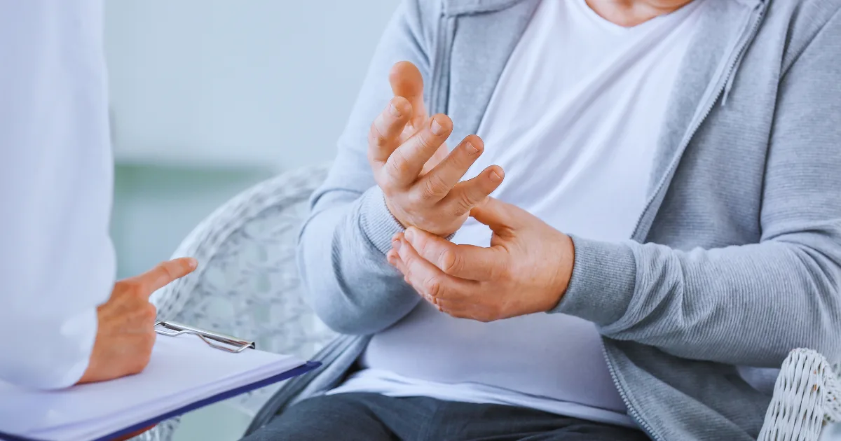 Patient showing hand tremor during consultation with doctor