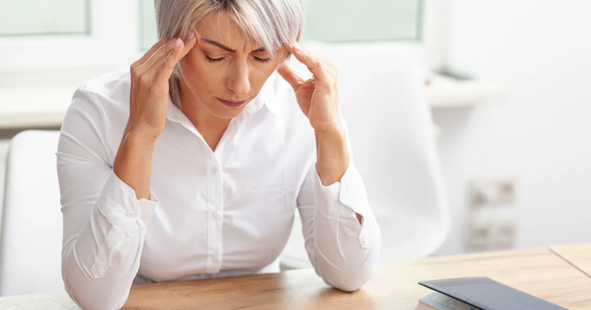 Stressed woman holding her temples, representing how stress affects brain health.