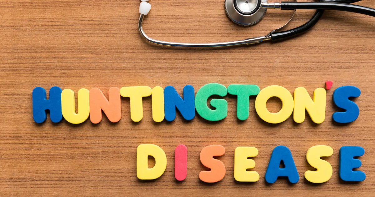 Colorful letters spelling “Huntington’s Disease” on a wooden surface with a stethoscope, representing chorea and its link to neurological disorders.