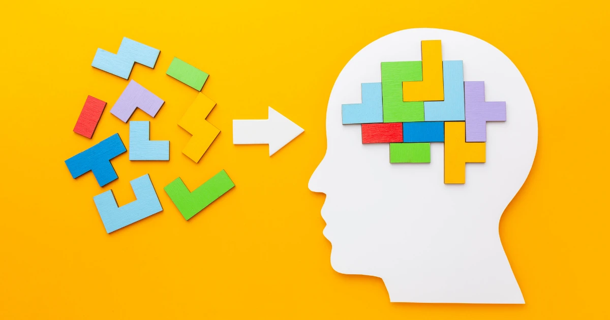 Brain exercises concept with colorful puzzle pieces forming a human head on yellow background.