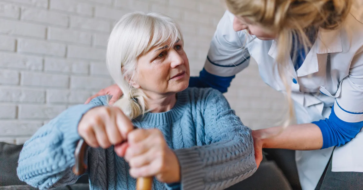 Doctor supporting a woman with early-onset Parkinson's disease.