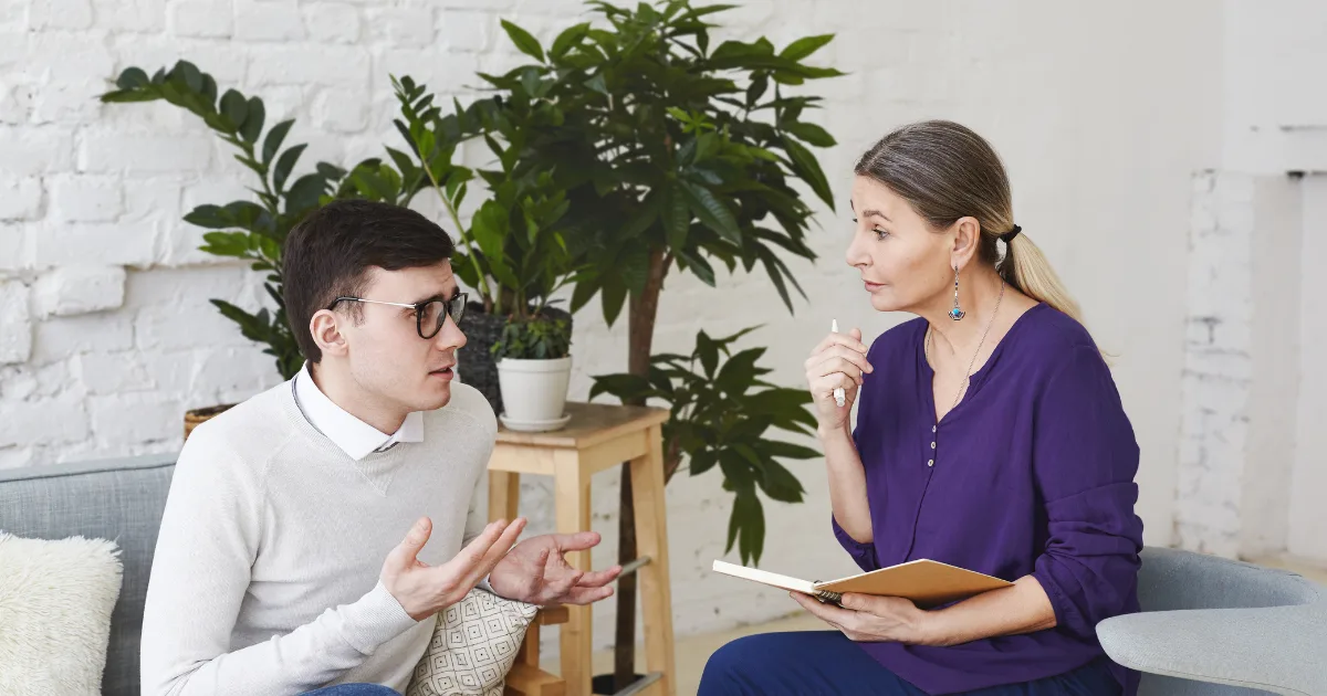 Speech therapist conducting a one-on-one session with a male patient, focusing on communication improvement through speech therapy.