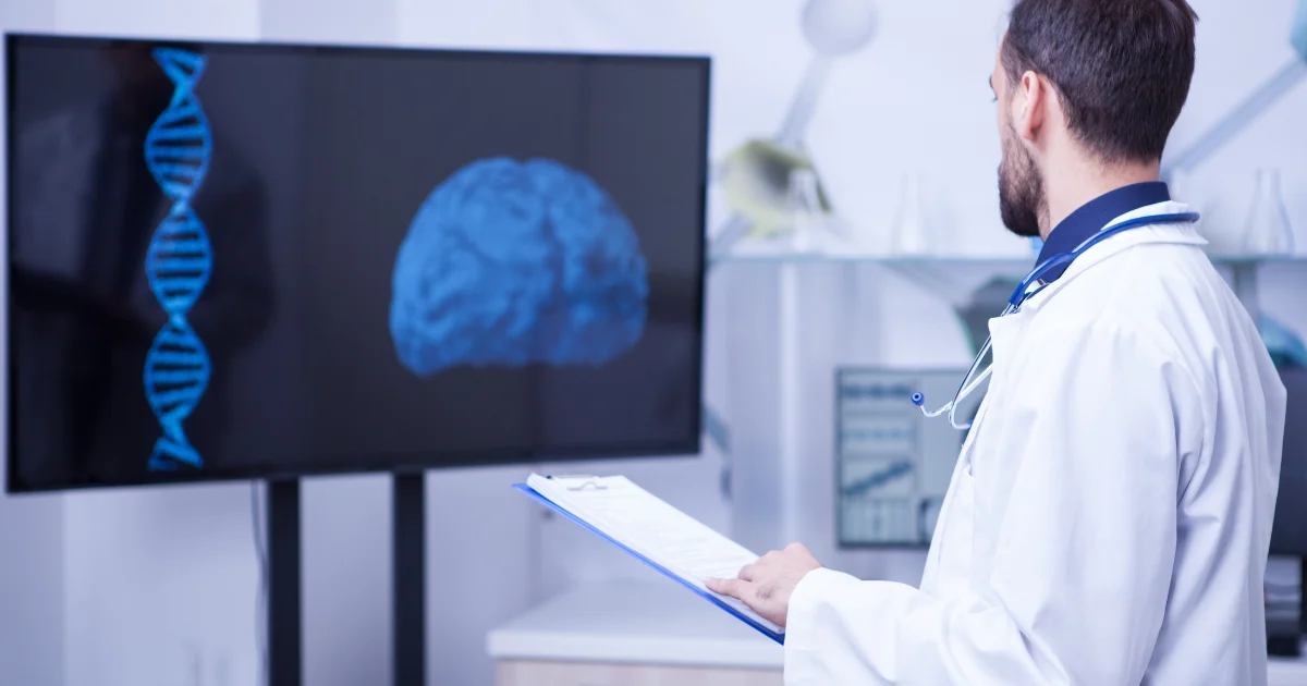 A medical professional studies a screen displaying digital illustrations of a DNA helix and a brain, symbolizing research on neurotransmitters.
