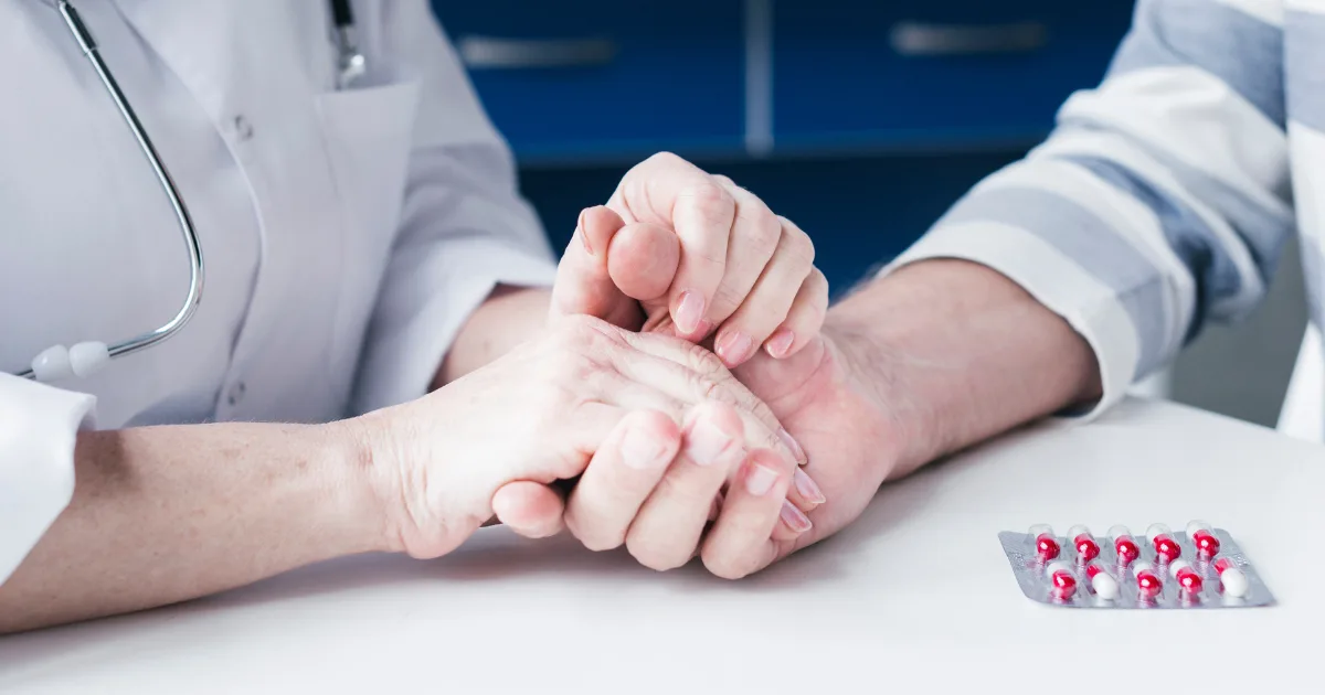 Parkinson’s Treatment Begin with doctor supporting patient’s hand and medicines on the table.