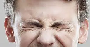 Close-up of an adult's head showing ears and hair, representing blepharospasm or focal dystonia