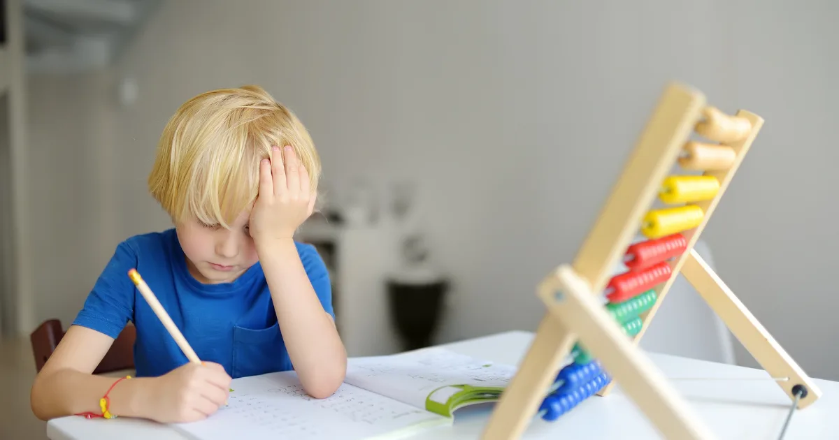 Child struggling with concentration and learning difficulties, symbolizing symptoms of Juvenile Huntington’s