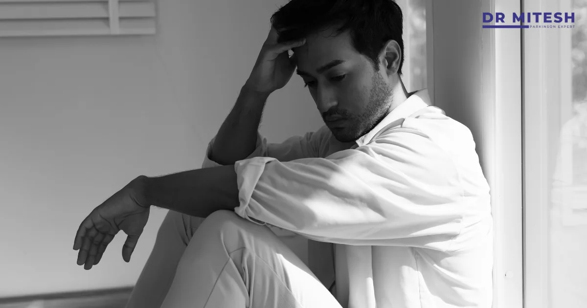 Man sitting alone looking distressed, often mistaken as a sign of mental illness but actually linked to sleep disorders like RBD.