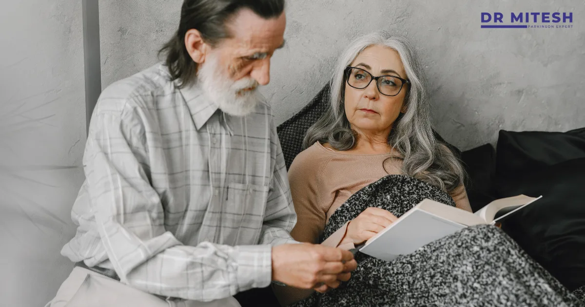 Elderly couple discussing health concerns showing challenges for spouse in Parkinson’s care