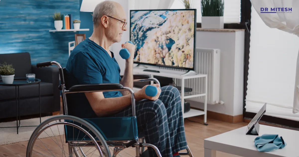 An elderly man with Parkinson’s disease exercising with dumbbells while sitting in a wheelchair at home.