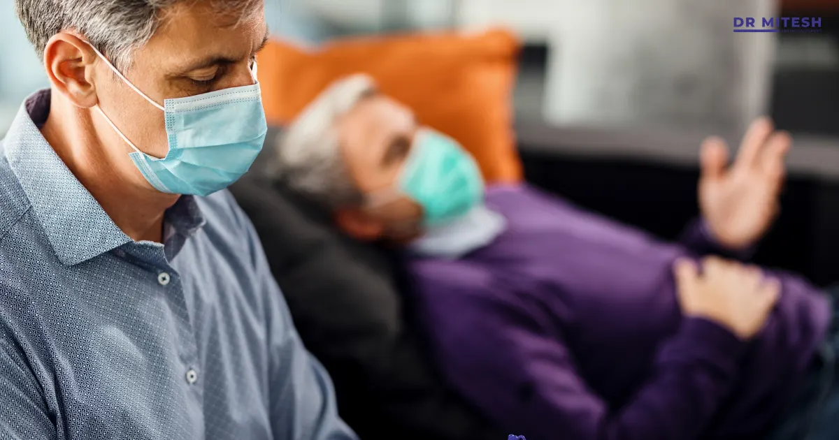 Caregiver wearing a face mask sitting beside a patient with essential tremor during a medical consultation.